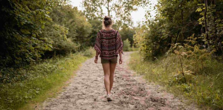 Femme sur un chemin dans la forêt